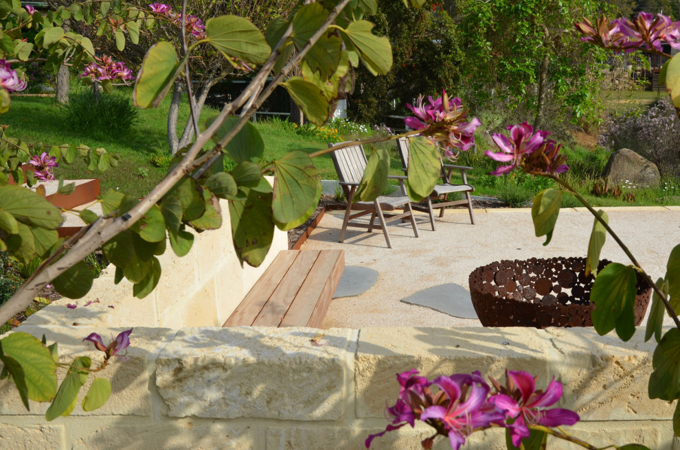 Идея дизайна: большой солнечный, весенний засухоустойчивый сад на переднем дворе в стиле рустика с местом для костра, хорошей освещенностью и покрытием из гравия