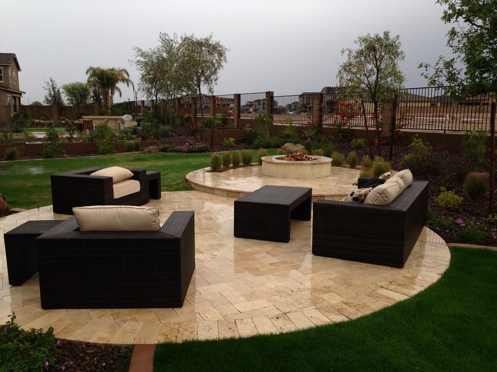 Design ideas for a mid-sized contemporary full sun backyard stone landscaping in Phoenix with a fire pit for winter.