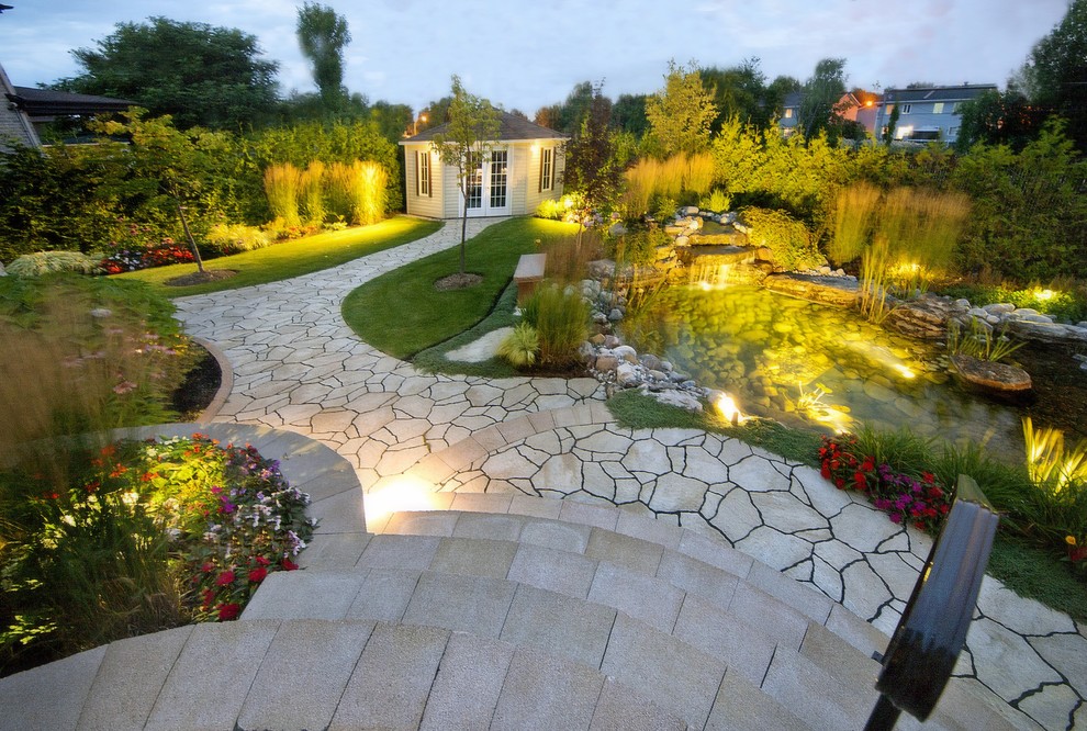 Foto de jardín asiático grande en patio trasero con jardín francés, fuente y adoquines de piedra natural