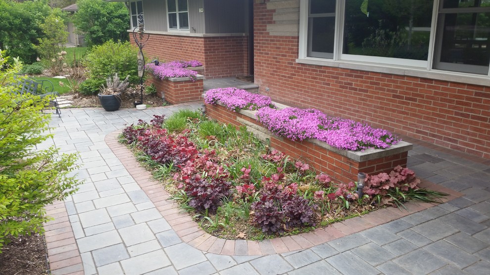 This is an example of a small modern front partial sun garden for summer in Chicago with a garden path and natural stone paving.
