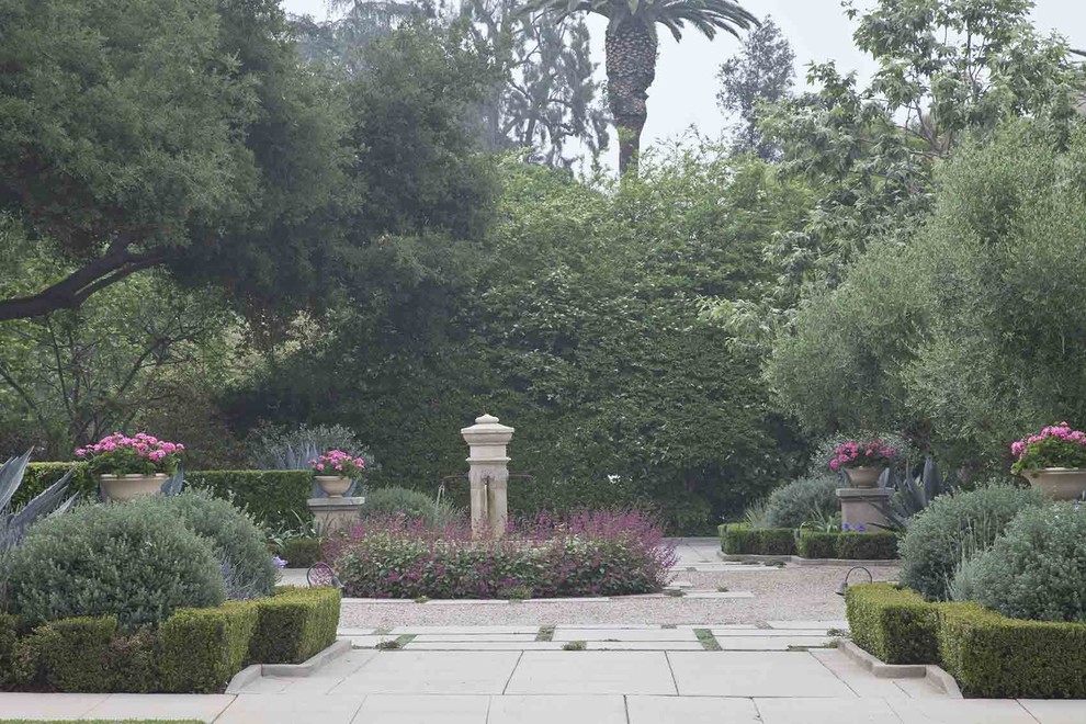 На фото: большой участок и сад на переднем дворе в средиземноморском стиле с подъездной дорогой и покрытием из гравия