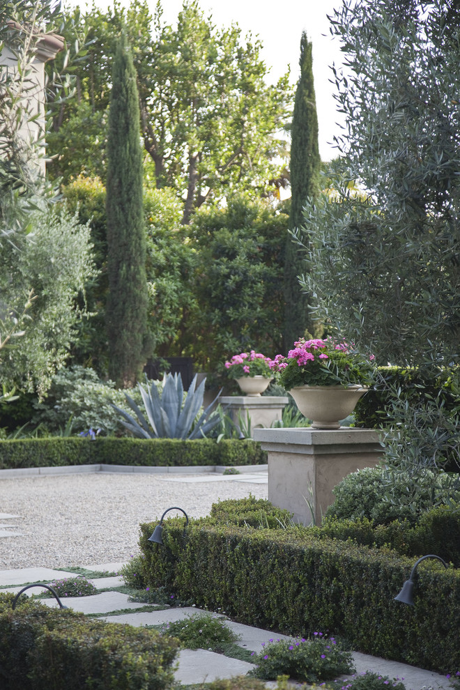 На фото: большой солнечный садовый фонтан на переднем дворе в средиземноморском стиле с подъездной дорогой, хорошей освещенностью и покрытием из гравия с