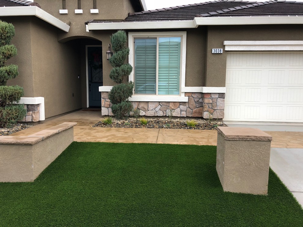 Foto di un giardino xeriscape minimalista esposto in pieno sole di medie dimensioni e davanti casa con un muro di contenimento e pavimentazioni in cemento