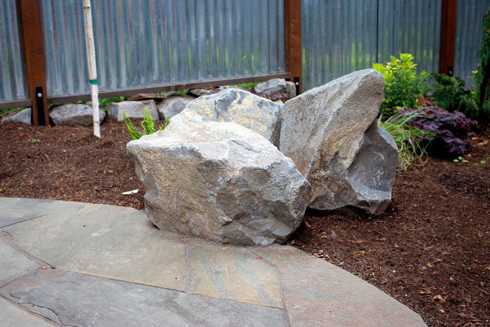 Inspiration pour un jardin arrière minimaliste de taille moyenne avec une exposition ensoleillée et des pavés en pierre naturelle.