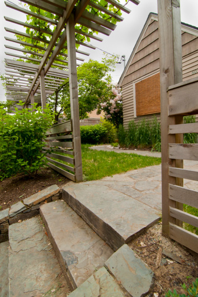 Idéer för en rustik trädgård framför huset, med en stödmur och naturstensplattor
