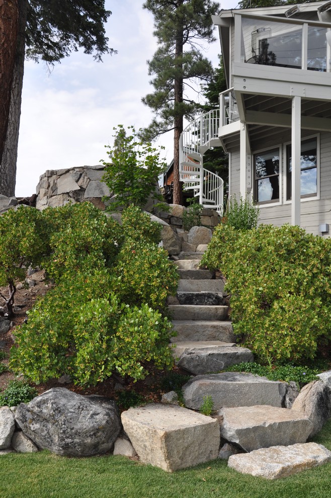 Idee per un grande giardino tradizionale dietro casa con pavimentazioni in pietra naturale e scale