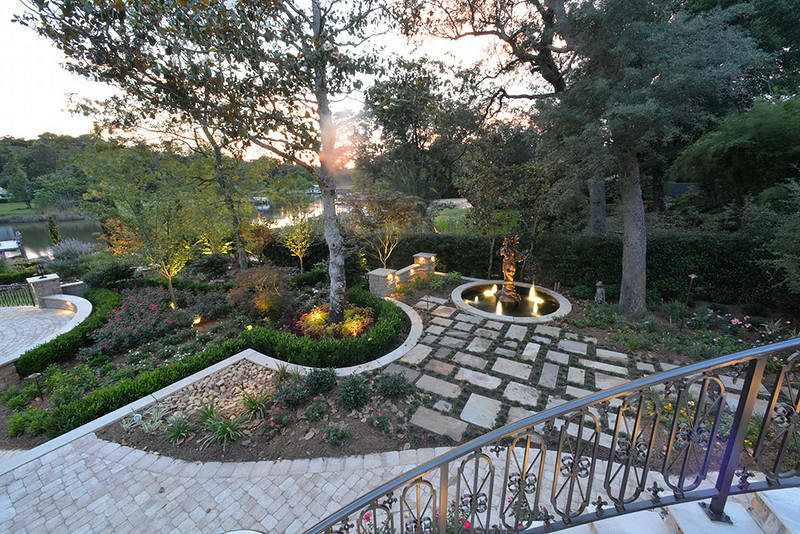 Exempel på en stor klassisk trädgård i delvis sol på våren, med en trädgårdsgång och naturstensplattor