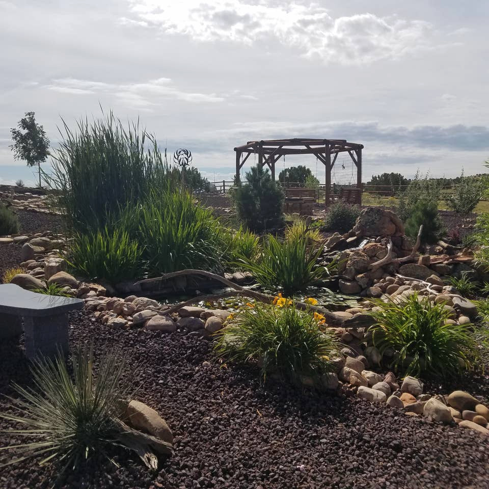 This is an example of a large back xeriscape full sun garden in Phoenix with a rockery and gravel.