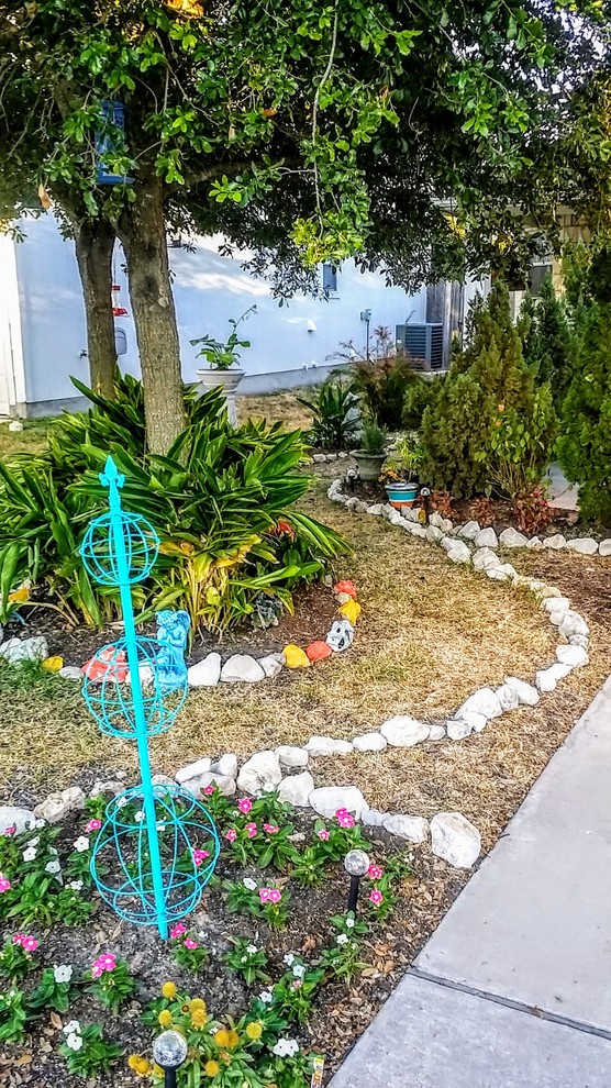 Cette image montre un petit jardin avant bohème au printemps avec une exposition partiellement ombragée et des pavés en pierre naturelle.