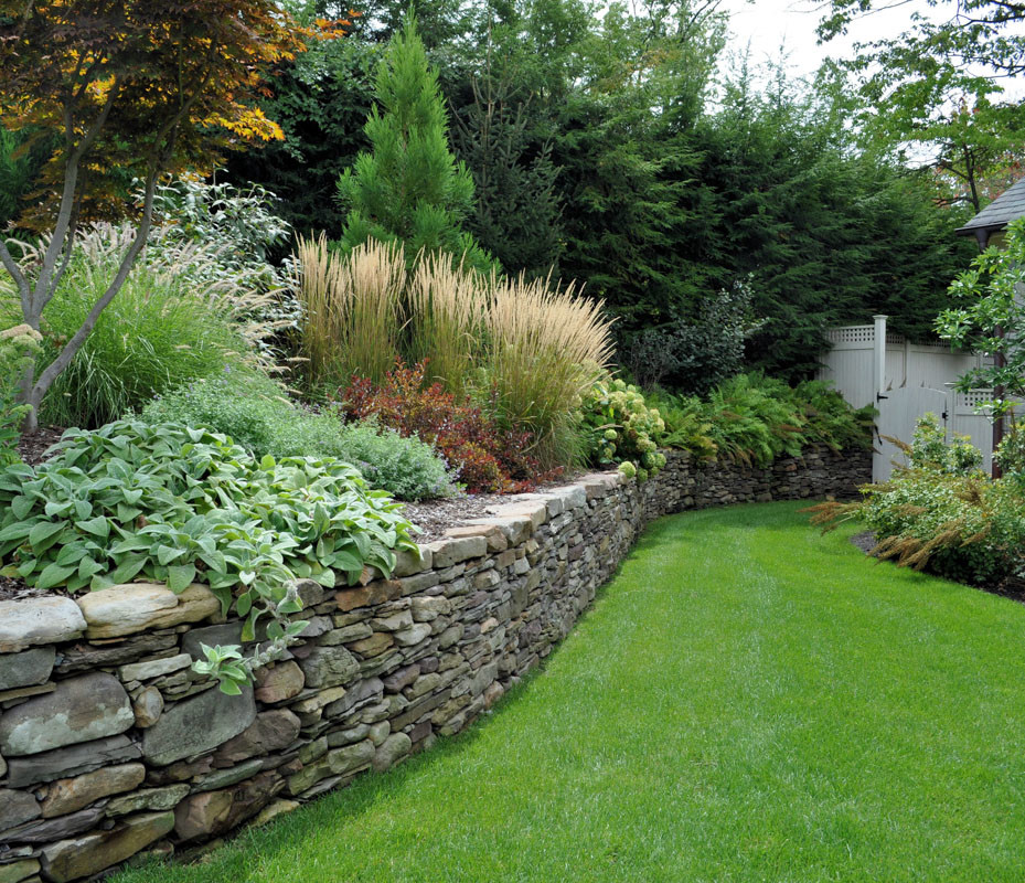 Photo of a traditional garden in New York with a retaining wall.