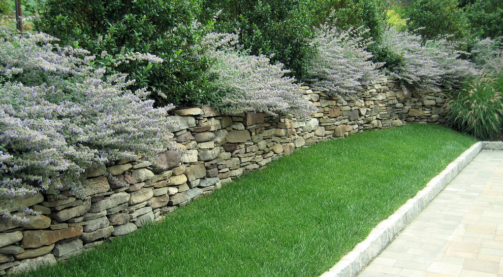 Diseño de jardín tradicional con muro de contención