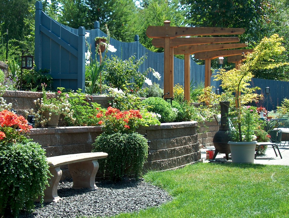 This is an example of a mid-sized mediterranean full sun backyard retaining wall landscape in Seattle.