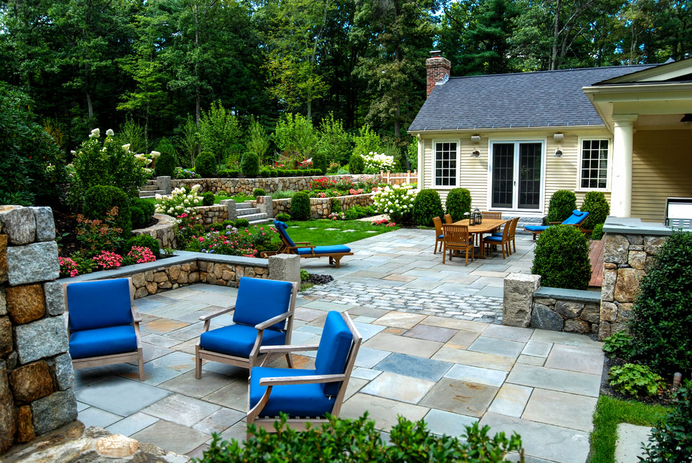 Imagen de jardín tradicional de tamaño medio en patio trasero con muro de contención y exposición total al sol