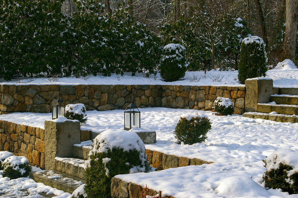 Inspiration för mellanstora klassiska bakgårdar i delvis sol på vinteren, med en stödmur