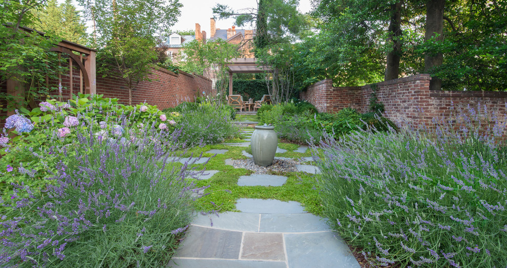 Immagine di un giardino chic esposto a mezz'ombra di medie dimensioni e dietro casa in primavera con fontane e pavimentazioni in pietra naturale