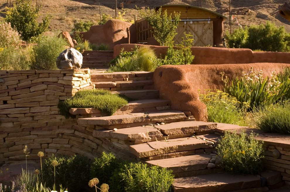 Photo of a bohemian sloped xeriscape full sun garden for spring in Salt Lake City with a garden path and natural stone paving.