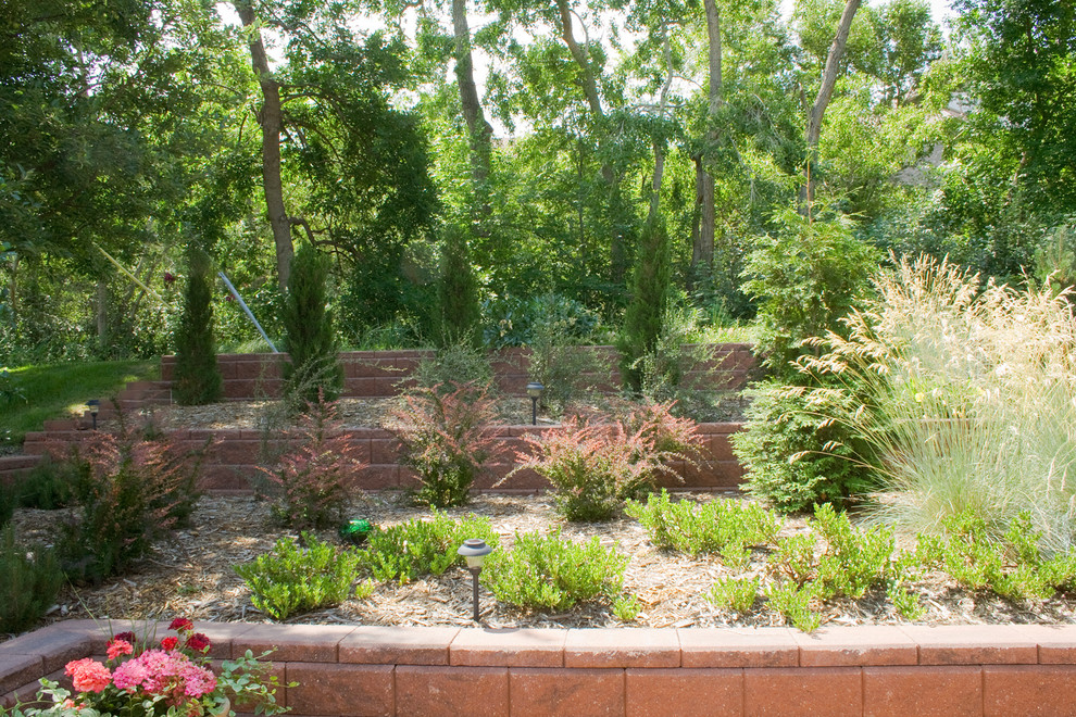 На фото: большой участок и сад на заднем дворе в современном стиле с подпорной стенкой, полуденной тенью и покрытием из каменной брусчатки с