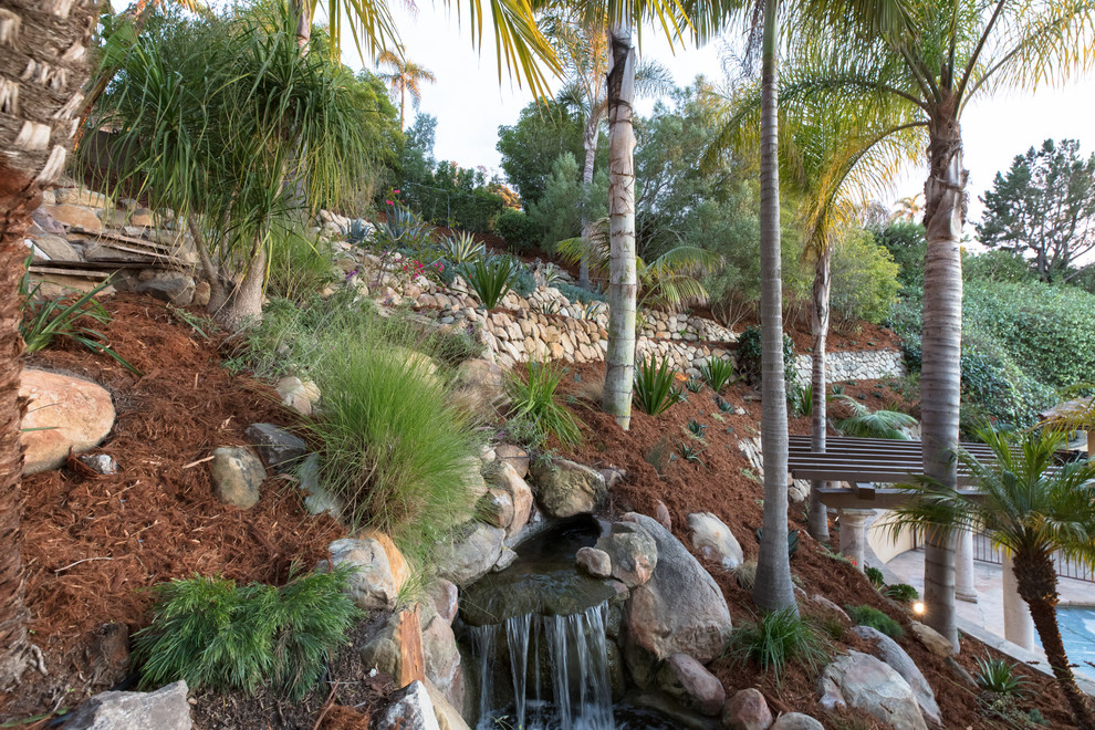 Стильный дизайн: солнечный участок и сад на склоне в средиземноморском стиле с хорошей освещенностью и покрытием из каменной брусчатки - последний тренд