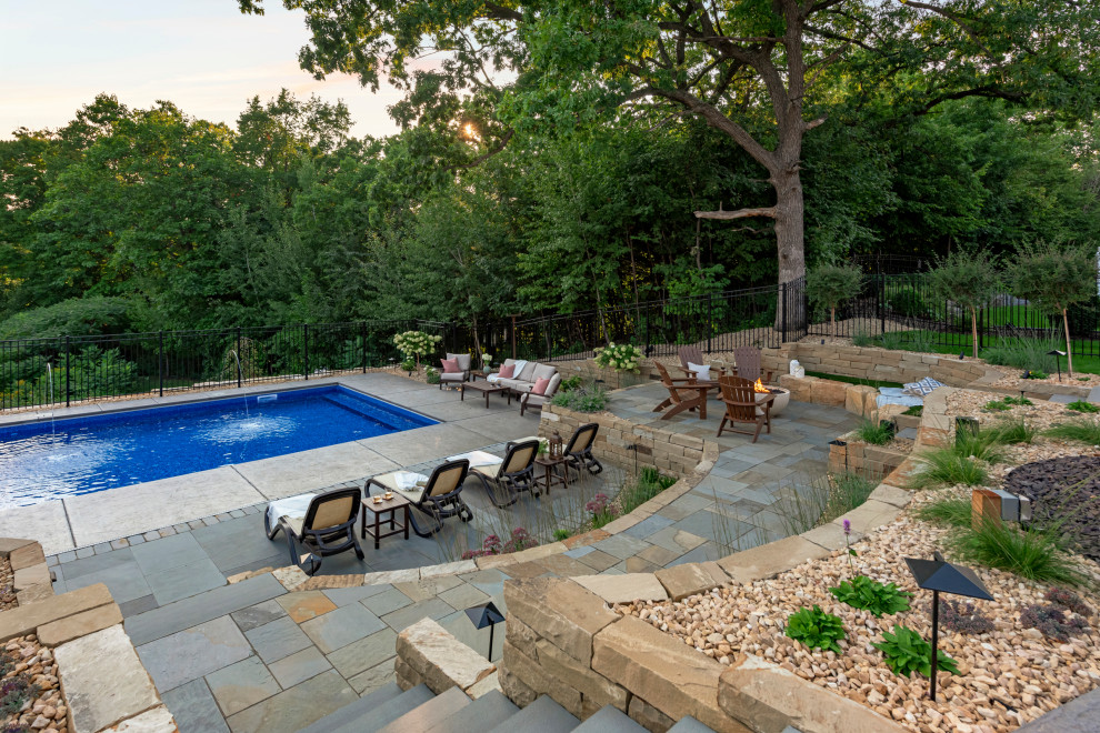Inspiration for a large classic back partial sun garden for summer in Minneapolis with a retaining wall and natural stone paving.