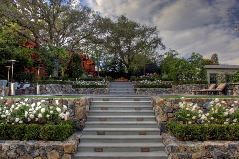 На фото: большой участок и сад на заднем дворе в классическом стиле с покрытием из каменной брусчатки с