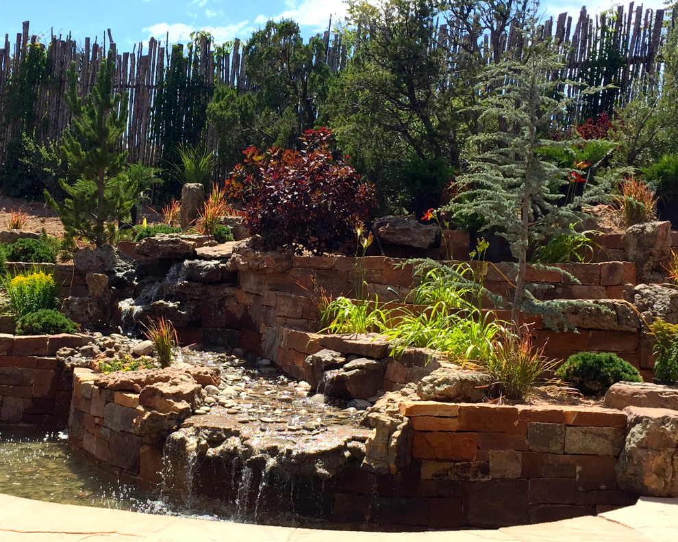This is an example of a mid-sized eclectic partial sun backyard stone landscaping in Albuquerque for summer.
