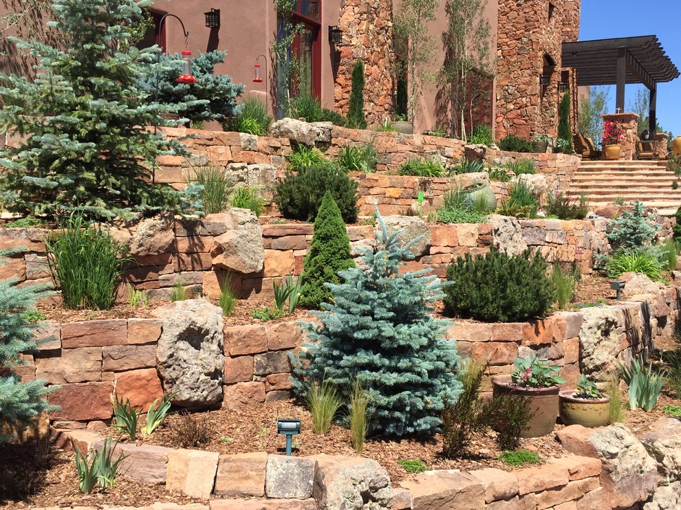 Idee per un grande giardino xeriscape american style esposto in pieno sole davanti casa in estate con pavimentazioni in pietra naturale e un muro di contenimento
