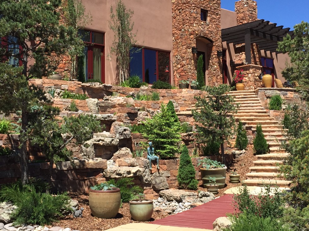 Design ideas for a mid-sized southwestern drought-tolerant and full sun front yard stone retaining wall landscape in Albuquerque for summer.
