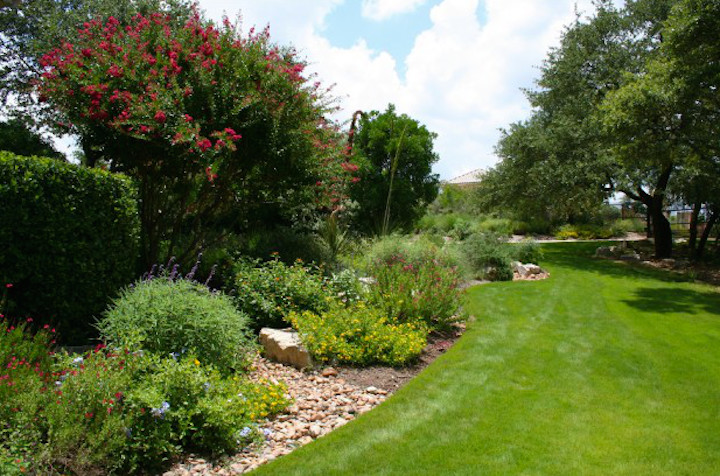 Immagine di un giardino chic esposto a mezz'ombra di medie dimensioni e dietro casa con un muro di contenimento e pavimentazioni in pietra naturale