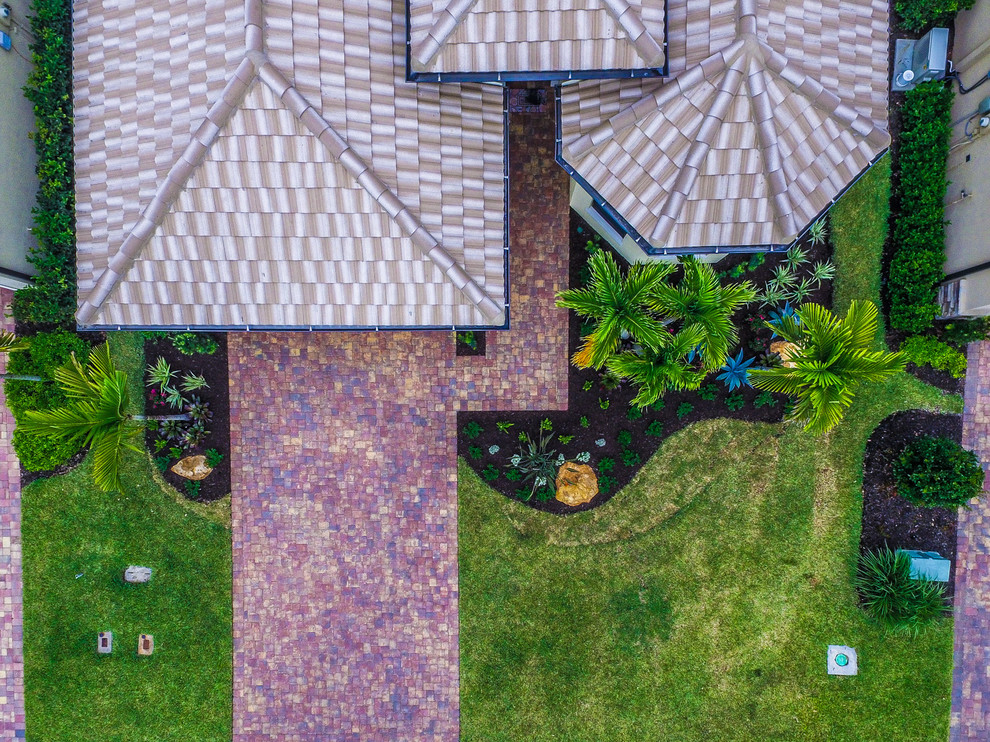 Ispirazione per un vialetto d'ingresso tropicale di medie dimensioni e davanti casa con pavimentazioni in pietra naturale