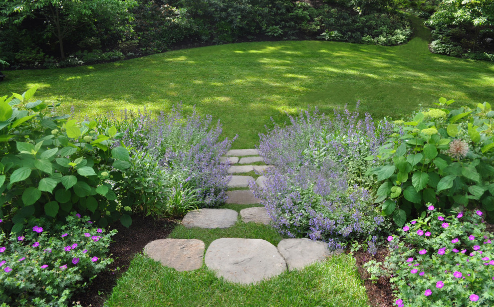 Cette image montre un jardin traditionnel de taille moyenne et l'été avec une pente, une colline ou un talus, des pavés en pierre naturelle et une exposition partiellement ombragée.