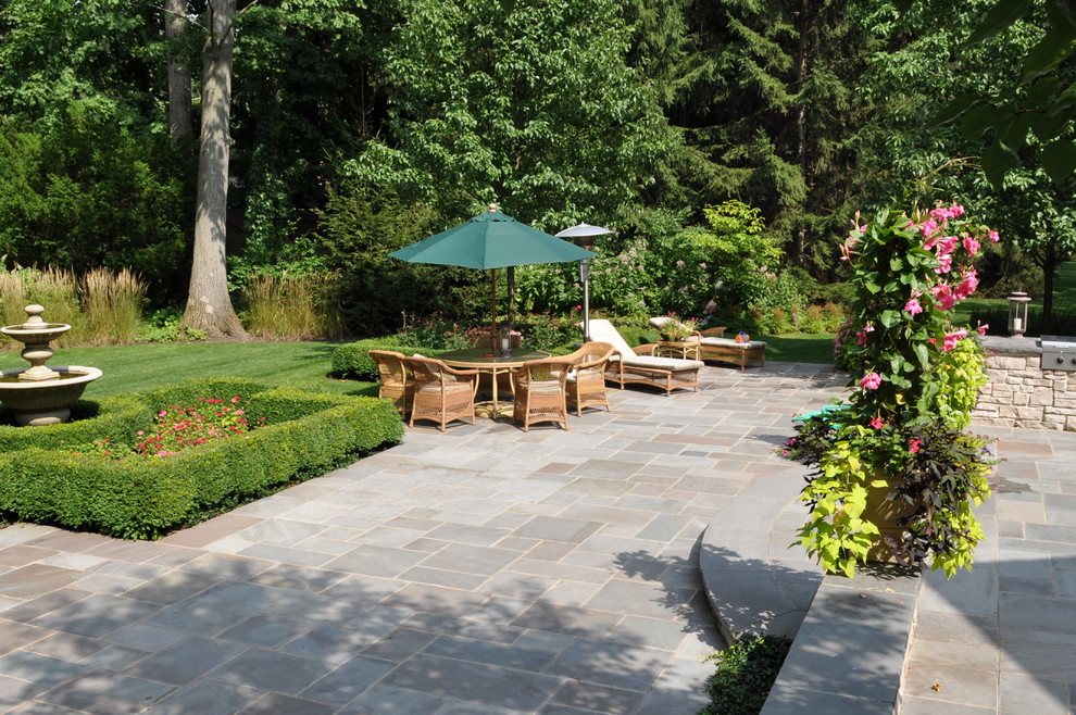 Cette photo montre un jardin arrière chic avec des pavés en pierre naturelle.