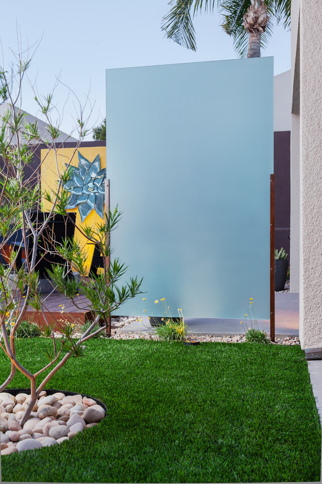 Immagine di un grande giardino moderno esposto a mezz'ombra dietro casa con un focolare