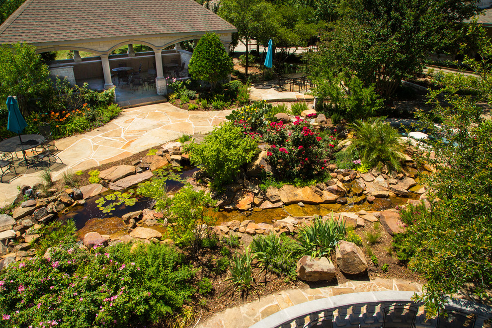 Inspiration for a large farmhouse drought-tolerant and full sun backyard stone pond in Dallas.