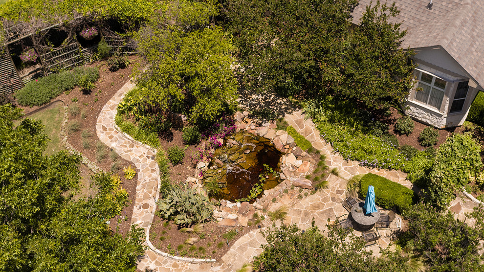 Immagine di un grande giardino country esposto in pieno sole davanti casa con pavimentazioni in pietra naturale
