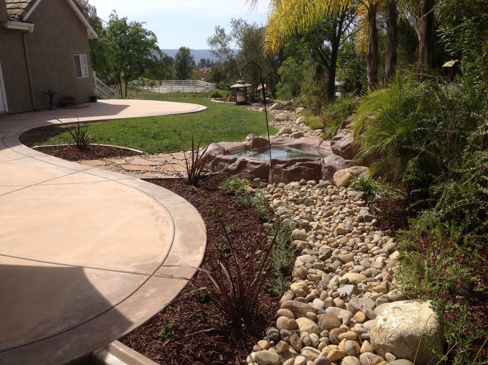 Inspiration for a medium sized mediterranean back full sun garden in San Diego with a water feature and gravel.