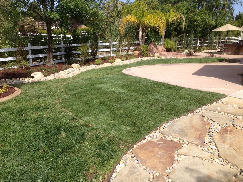 This is an example of a mid-sized mediterranean full sun backyard gravel water fountain landscape in San Diego.