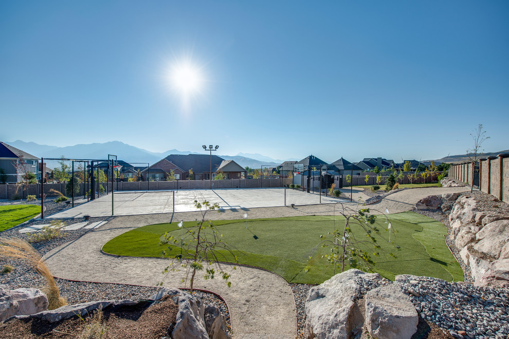 Immagine di un ampio campo sportivo esterno classico esposto in pieno sole dietro casa in estate con ghiaia