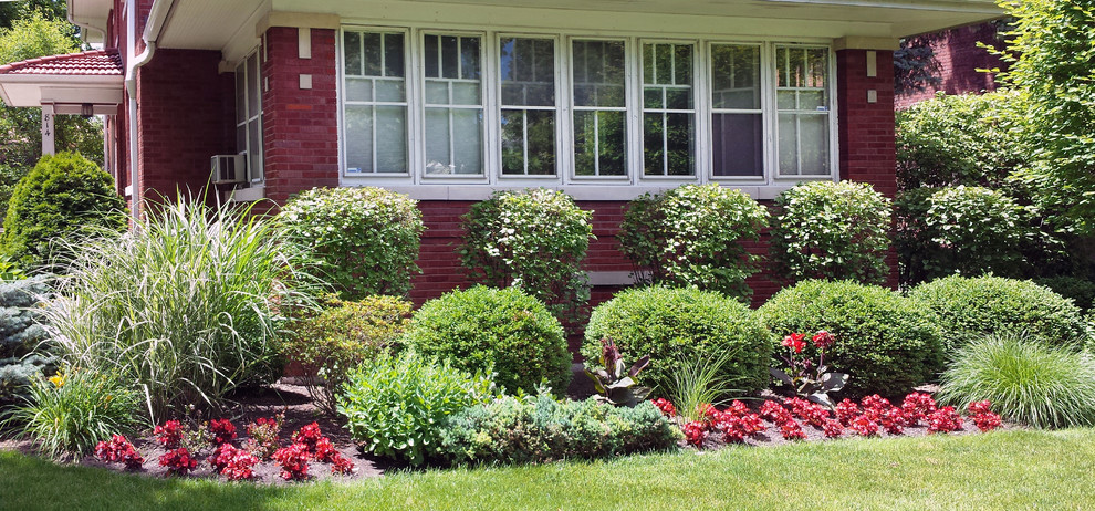 Imagen de jardín tradicional renovado de tamaño medio en patio delantero con exposición total al sol y adoquines de ladrillo