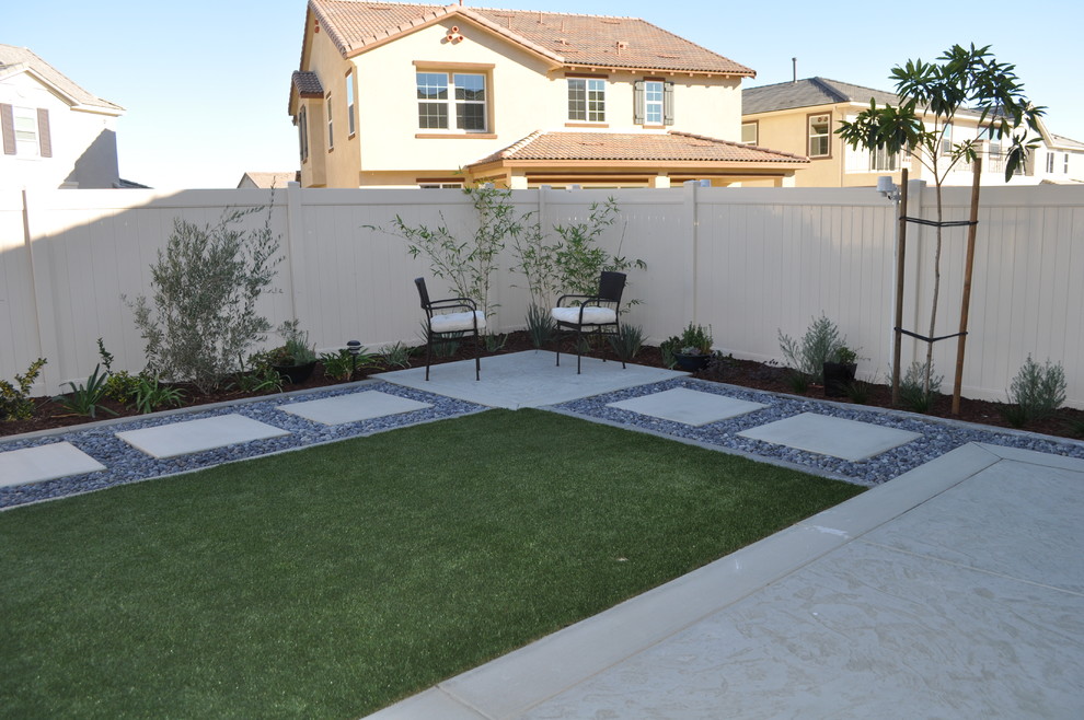Photo of a small modern back xeriscape partial sun garden in San Diego with concrete paving.