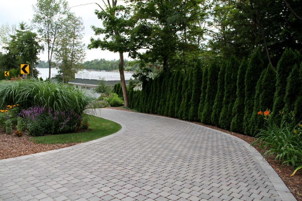This is an example of a mid-sized contemporary front yard concrete paver driveway in Other.