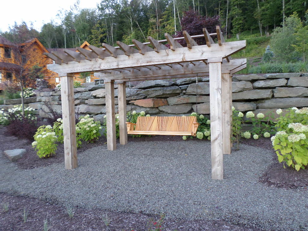 Inspiration for a large rustic back xeriscape partial sun pergola in New York with gravel.
