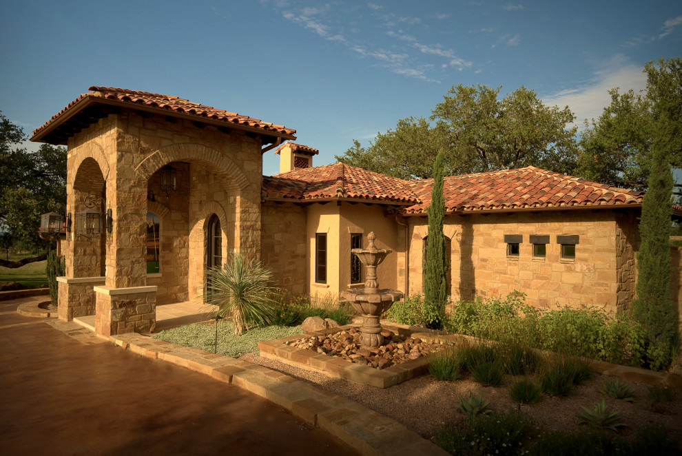 Photo of a mid-sized mediterranean full sun front yard stone landscaping in Austin.