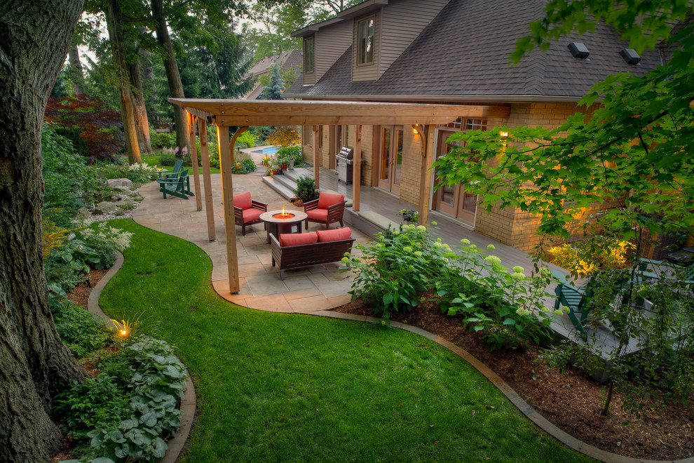 Photo of a large traditional backyard stone landscaping in Toronto.