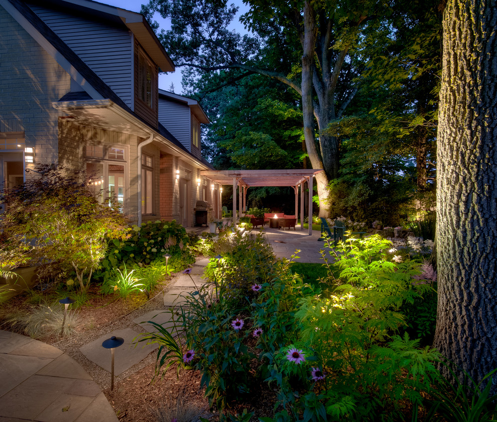 Inspiration pour un grand jardin arrière traditionnel avec un foyer extérieur, une exposition ombragée et des pavés en pierre naturelle.