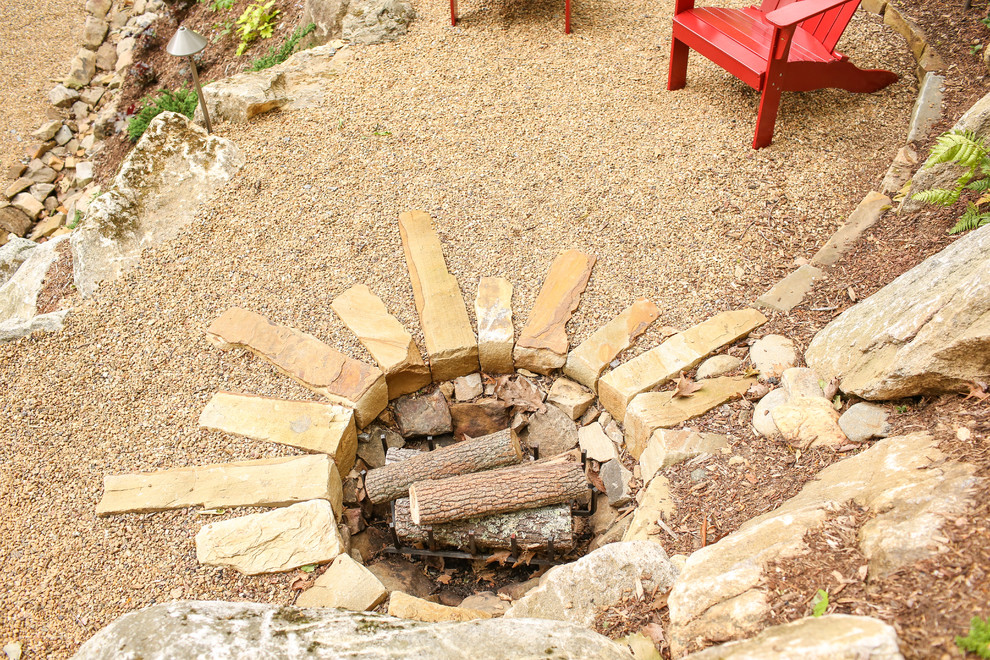 Photo of a mid-sized traditional shade hillside stone landscaping in Charlotte with a fire pit for summer.
