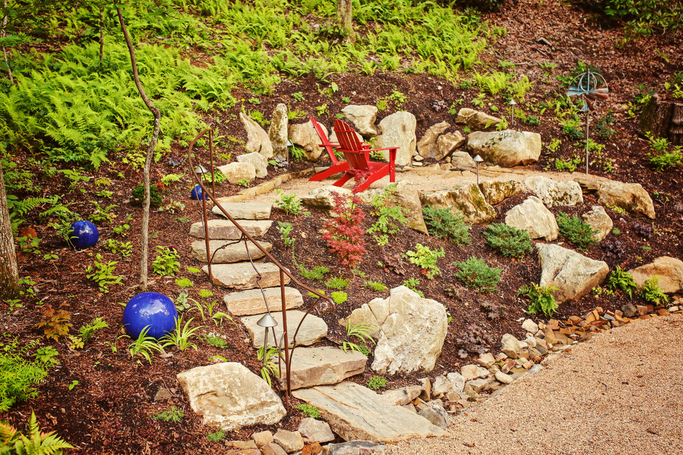 Photo of a mid-sized traditional shade hillside gravel landscaping in Charlotte with a fire pit for summer.