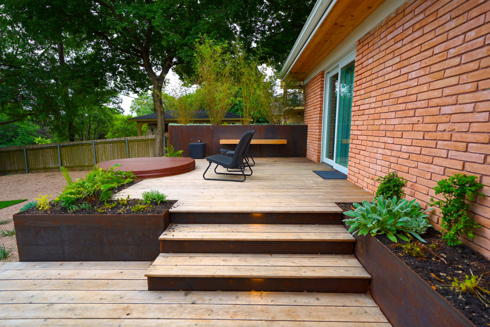 Design ideas for a small midcentury back formal and private partial sun garden in Austin with decking.