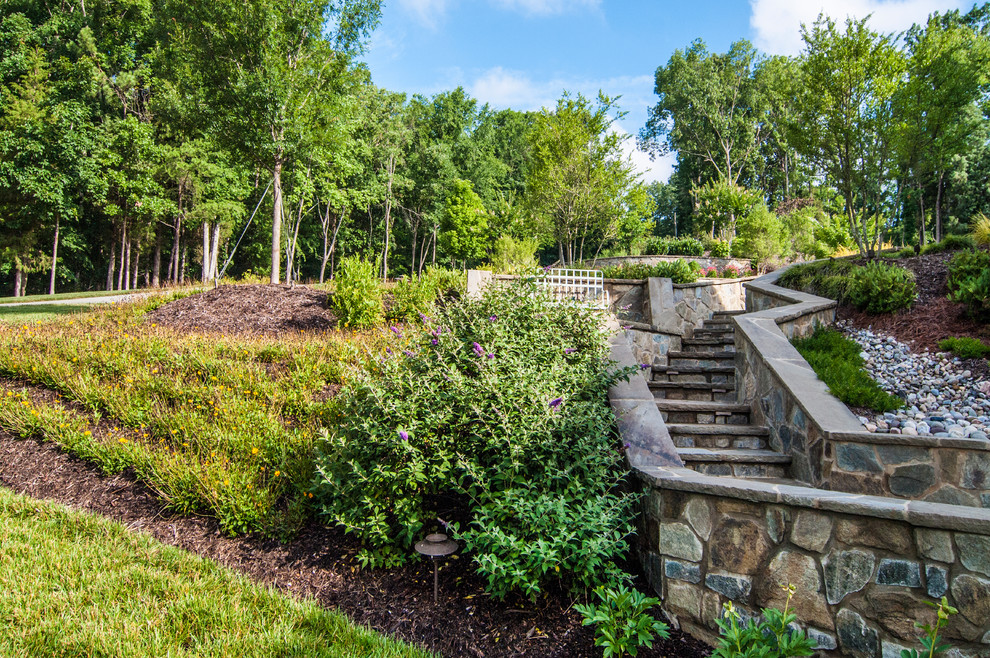 Photo of a classic sloped garden in Charlotte with natural stone paving.