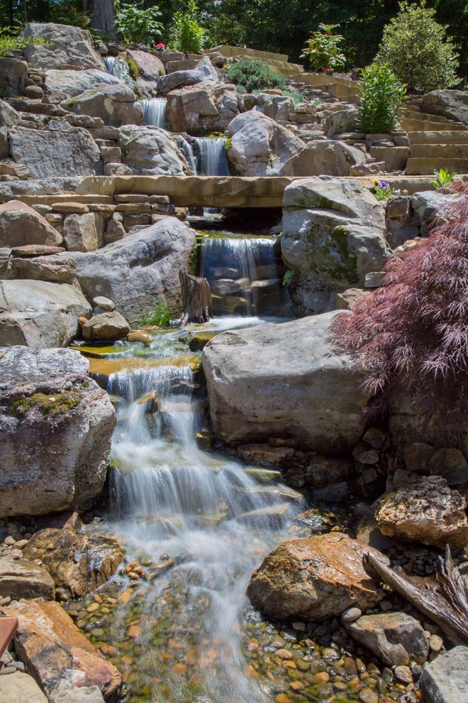Imagen de jardín de estilo zen grande en ladera con estanque y exposición total al sol