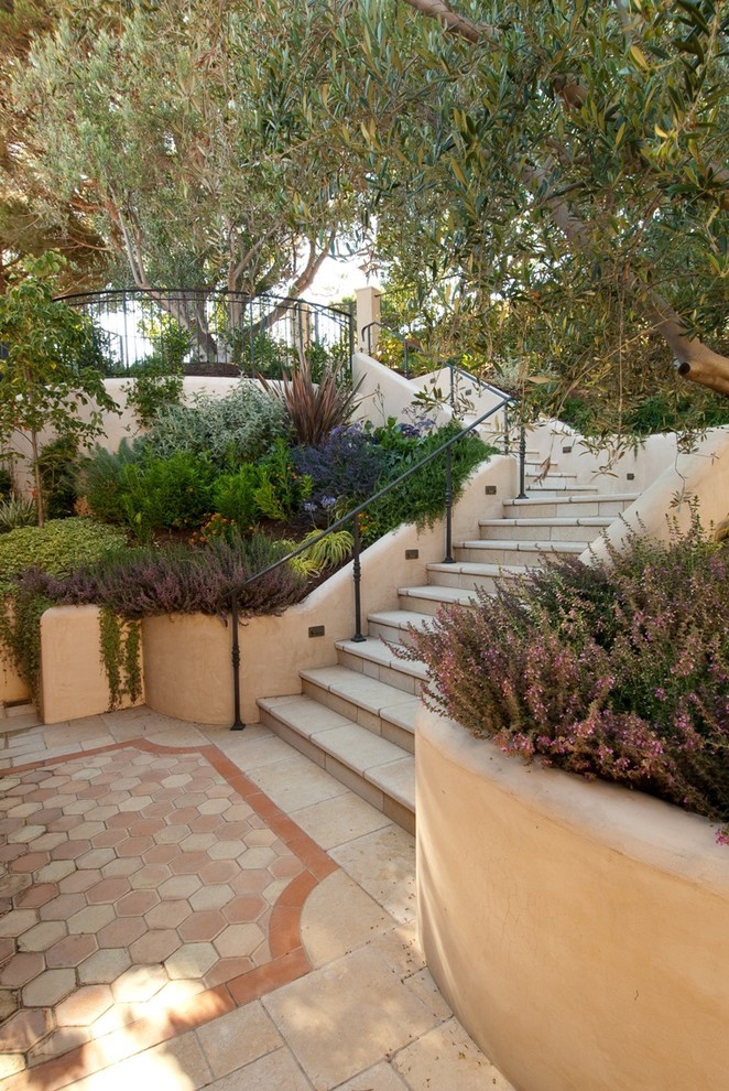 На фото: участок и сад на склоне в средиземноморском стиле с покрытием из каменной брусчатки